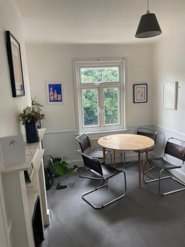 ein Wohnzimmer mit einem Tisch und Stühlen in der Unterkunft 16 Beverstone road in London