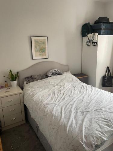 ein Schlafzimmer mit einem Bett mit einer weißen Bettdecke in der Unterkunft 16 Beverstone road in London