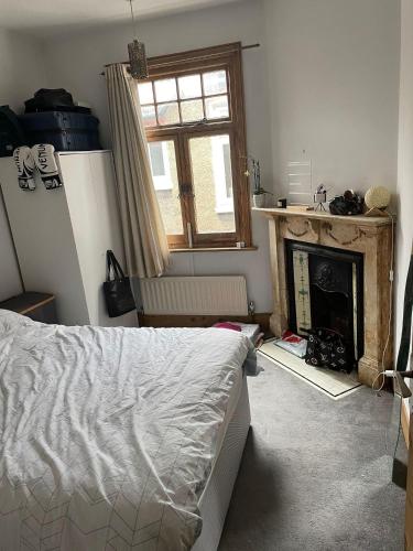 1 dormitorio con 1 cama y chimenea en 16 Beverstone road en Londres