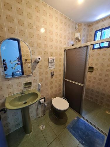 a bathroom with a sink and a toilet and a mirror at Soul Hostel Natal in Natal