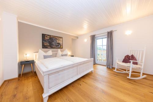 a white bedroom with a bed and a window at Chalet "Villa Marlene" in Zell am See