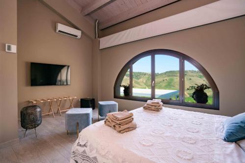a bedroom with a bed and a large window at Judeka Agriresort in Caltagirone