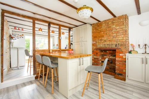 a kitchen with white cabinets and a brick wall at Newgate House, Sandwich in Sandwich