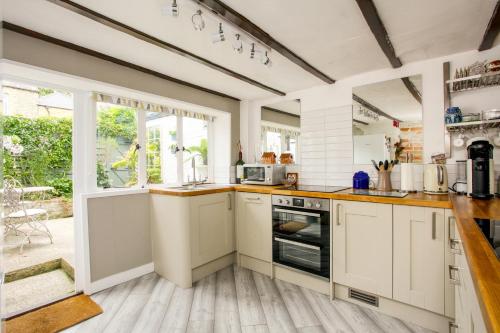 a kitchen with white cabinets and a large window at Newgate House, Sandwich in Sandwich