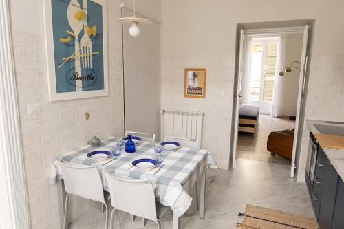 uma mesa branca com cadeiras brancas e uma cozinha em Al n°35 - Una volta a Torino em Turim