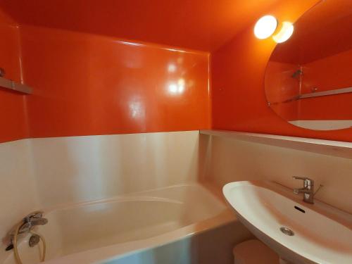 La salle de bains est pourvue d'une baignoire, d'un lavabo et d'un miroir. dans l'établissement Appartement Les Arcs 1800, 2 pièces, 5 personnes - FR-1-411-694, à Bourg-Saint-Maurice