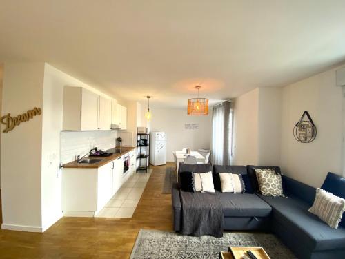 un salon avec un canapé bleu et une cuisine dans l'établissement COCCON 2 By Dream Apartments, à Serris