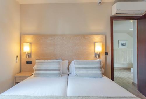 a bedroom with two beds with white pillows at Marins Playa in Cala Millor