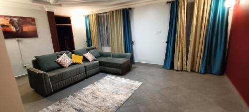 a living room with a couch and a chair at Cosy Living in Gulu