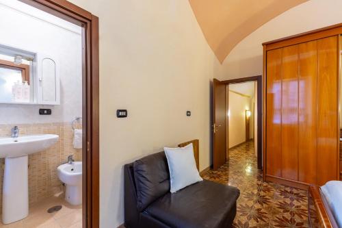 een badkamer met een zwarte leren stoel en een wastafel bij Amphitheater Apartment by Wonderful Italy in Napels