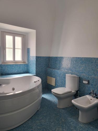 a bathroom with a tub and a toilet and a sink at Solar de Arrayollos Charming House in Arraiolos