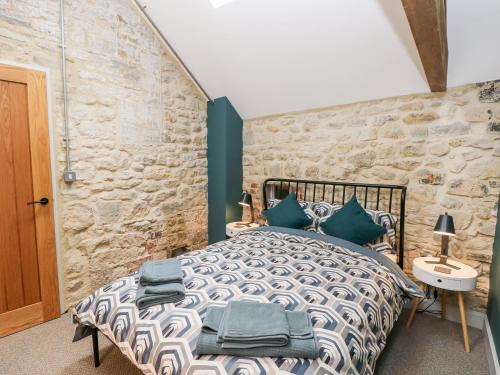 a bedroom with a bed and a stone wall at Tower Barn Cottage in Ryde