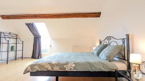 um quarto com uma cama com um edredão azul em Le Gîte des Roses em Essey