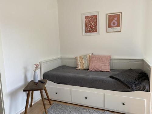 ein weißes Schlafzimmer mit einem Bett mit einer Schublade in der Unterkunft Albnest in Mössingen