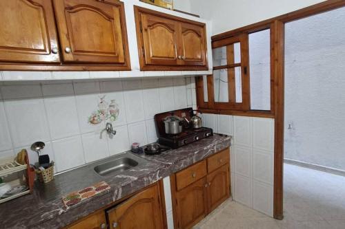 a kitchen with wooden cabinets and a sink and a counter top at Apparemment meublé à Kénitra in Kenitra