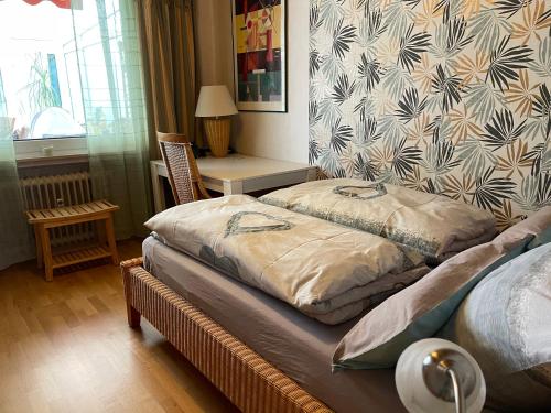 a bedroom with two beds and a table with a window at Ferienwohnung Zur Heide in Rheine