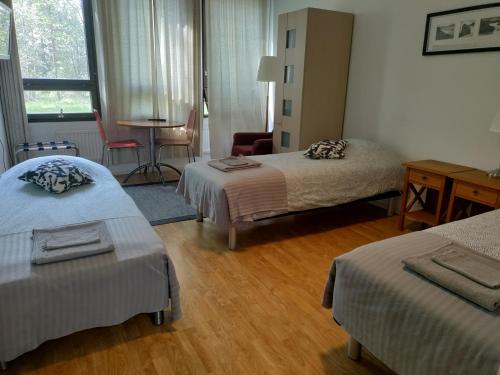 um quarto de hotel com duas camas e uma mesa em Hostel Vekotin em Toijala