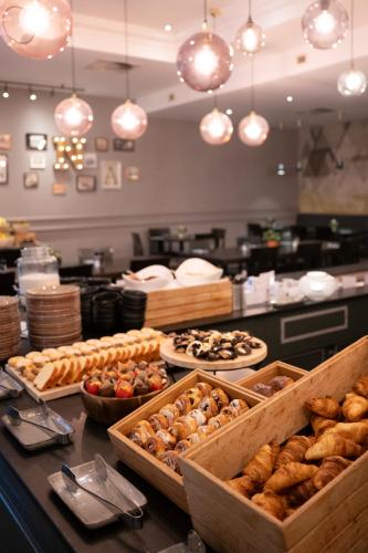 a bakery with many different types of pastries on a counter at Crowne Plaza Antwerpen by IHG in Antwerp