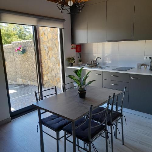 a kitchen with a wooden table with chairs and a plant on it at leiria village casa village in Leiria