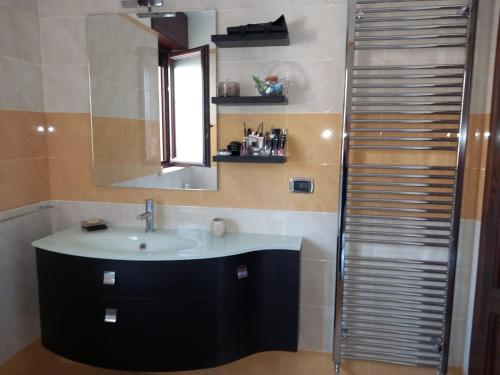 a bathroom with a sink and a mirror and a shower at Casa di Ale in Trepuzzi
