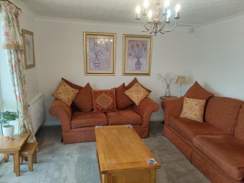 a living room with two couches and a table at Split Level Bungalow - Sleeps4 - Close to walks in Sutton in Ashfield
