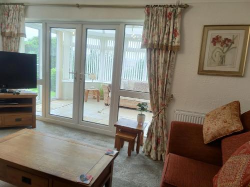 a living room with a couch and a tv at Stunning Views Peaceful Split Level Bungalow in Sutton in Ashfield