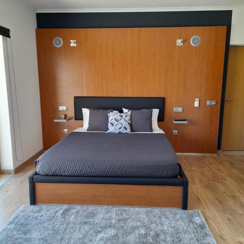 a bedroom with a large bed with a wooden headboard at leiria village casa village in Leiria