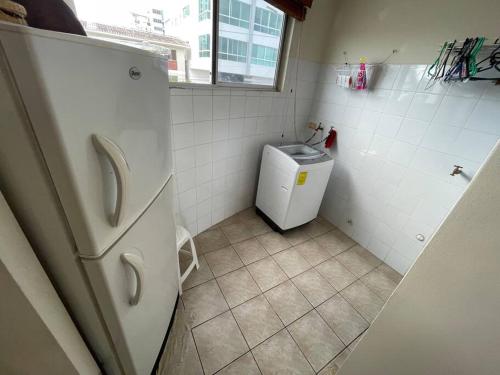 a small bathroom with a refrigerator and a sink at Condominio vizcaya in Salinas