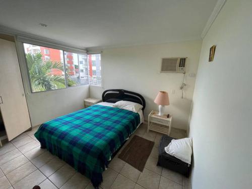 ein kleines Schlafzimmer mit einem Bett und einem Fenster in der Unterkunft Condominio vizcaya in Salinas