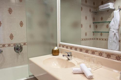 a bathroom with a sink and a shower with a mirror at Starhotels Vespucci in Campi Bisenzio