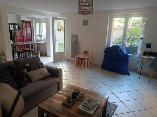 a living room with a couch and a table at Havre de paix Les pélicans in Vichy