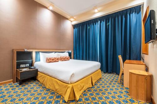 a hotel room with a bed and a tv at Elite Crystal Hotel in Manama