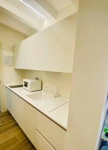 a kitchen with white cabinets and a microwave at Star Soave Rooms - Locazione Turistica in Soave