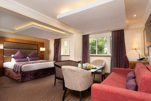 um quarto de hotel com uma cama e uma mesa em Donnington Manor Hotel em Sevenoaks