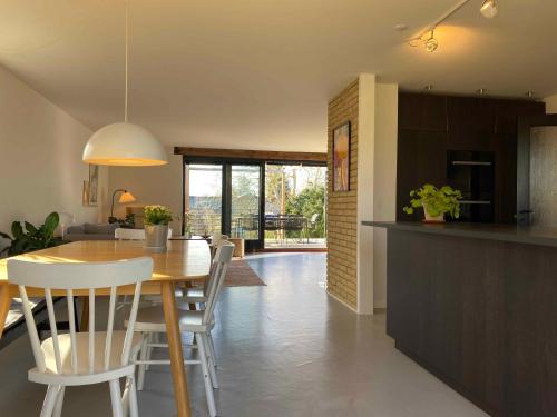 a kitchen and dining room with a table and chairs at Cheerful 3-bedroom Home, Close To Lakes in Farum