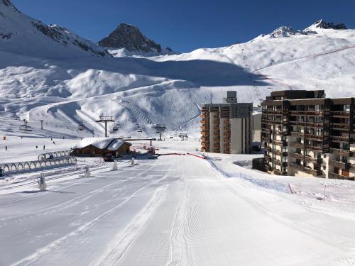 a snow covered mountain with a building and a ski slope at Tignes : cocon luxueux au pied des pistes in Tignes