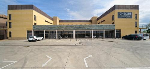 a large building with cars parked in a parking lot at Checkin Madrid Móstoles in Móstoles