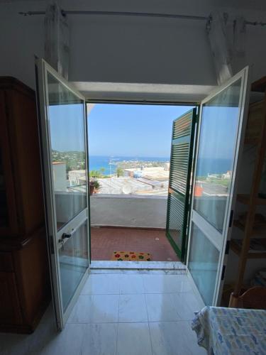 una porta aperta su un balcone con vista sull'oceano di A cas e Rosa a Ischia