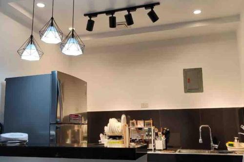 a kitchen with three lights hanging from the ceiling at Golden Mountain Homestay in Rizal