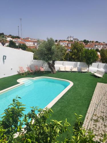 una piscina en un patio con césped verde en Solar de Arrayollos Charming House en Arraiolos