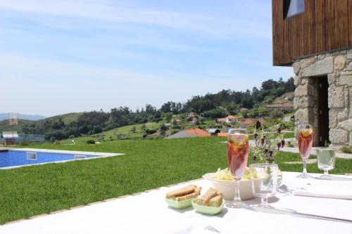 a table with two glasses of wine and a plate of food at Casas da Li in Arcos de Valdevez