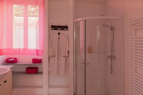 y baño con ducha y paredes de color rosa. en AU PLAISIR D ETAPE- ACCUEIL PELERINS uniquement, en Condom