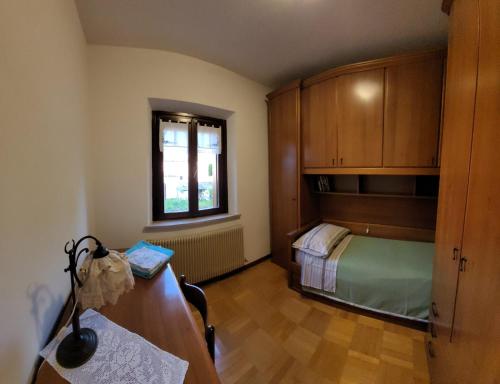 1 dormitorio con cama, escritorio y ventana en Morgen en Aquiléia