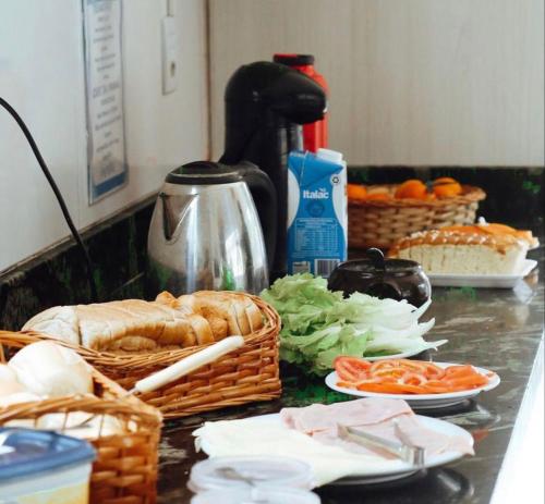 un comptoir de cuisine avec des paniers de pain et de légumes dans l'établissement Sea Wolf Hostel - Lagoa da Conceição, à Florianópolis