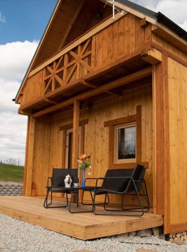 a cabin with two chairs and a table on a deck at Rajskie wzgórze w Karkonoszach in Łomnica