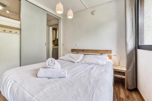 une chambre avec un lit blanc et un miroir dans l'établissement Aiguille du Grépon - Bright Apartment in the Heart of Chamonix, à Chamonix-Mont-Blanc