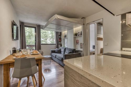 une cuisine et un salon avec une table et un canapé dans l'établissement Aiguille du Grépon - Bright Apartment in the Heart of Chamonix, à Chamonix-Mont-Blanc