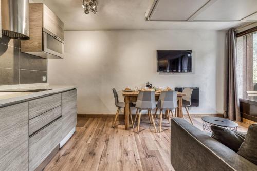 une cuisine et un salon avec une table et un canapé dans l'établissement Aiguille du Grépon - Bright Apartment in the Heart of Chamonix, à Chamonix-Mont-Blanc