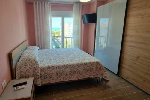 een slaapkamer met een bed in een kamer met een raam bij H&E Sea view 2-Bedroom Apt Qerret in Golem
