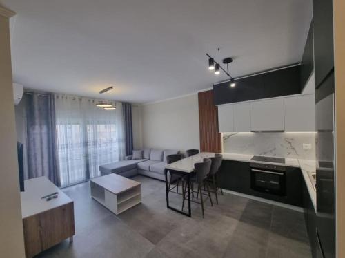een keuken en een woonkamer met een bank en een tafel bij H&E Sea view 2-Bedroom Apt Qerret in Golem